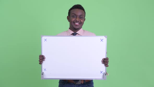 Happy Young African Businessman Thinking While Holding White Board