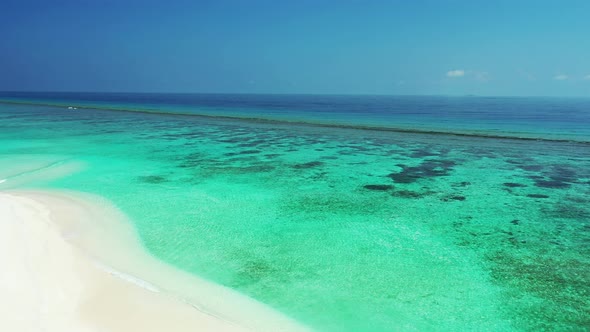 Wide birds eye travel shot of a white paradise beach and aqua turquoise water background in 4K