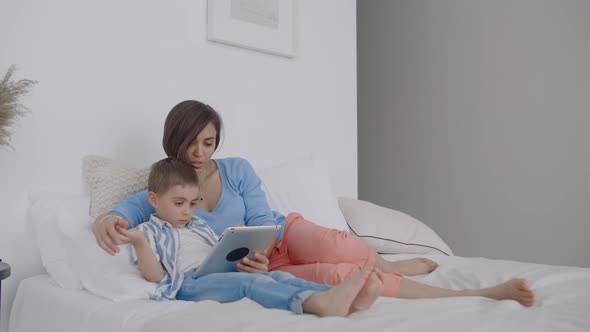 Happy Family Mother and Child Son with Tablet in Evening