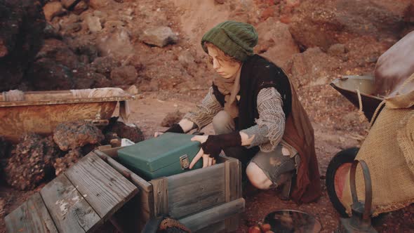 Woman Taking Old Record Player from Box at Dystopian Campsite