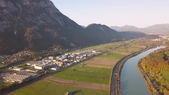 Aerial view of highway interstate road with fast moving traffic near big river in Alps mountains