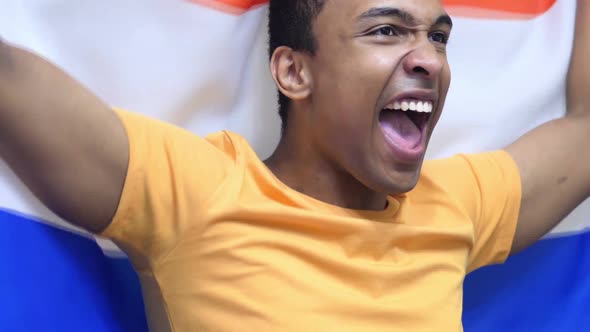 Netherlands Fan Celebrating While Holding the Flag of Netherlands in Slow Motion