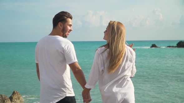 Young Couple Standing at the Sea Cost Admiring Beautiful Seascape, Man and Woman Hold Each Other