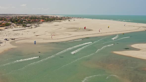 Several kite surfers sail and play together in isolated pond on Brazilian beach