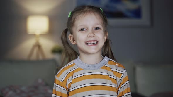 Little Girl Child Sitting On Sofa At Home