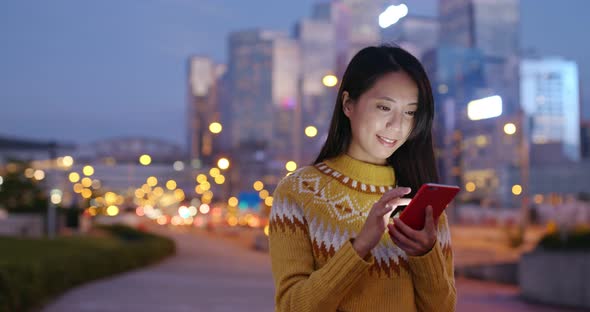 Asian woman use of mobile phone in city at night
