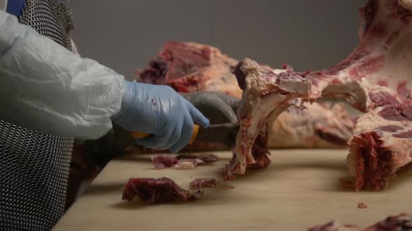 Butcher Cuts Raw Meat with Knife