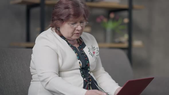 Medium Shot of Confident Senior Caucasian Woman Waving and Talking at Laptop Web Camera