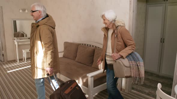 Delighted Senior Caucasian Couple Moving into Hotel Room