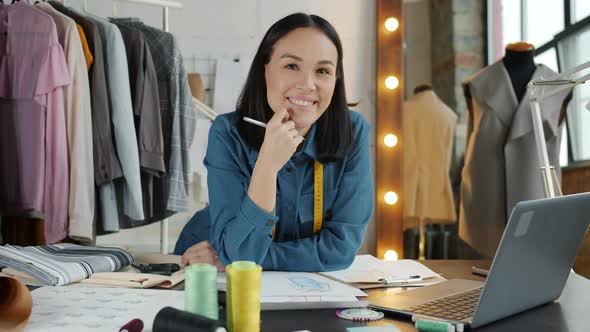 Successful Fashion Designer Smiling Inside Modern Showroom Looking at Camera