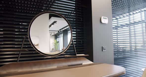 Modern wooden boudoir table with minimalist round mirror with room flowers.