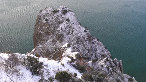 Snow Covered Rocky Cliffs Over Sea