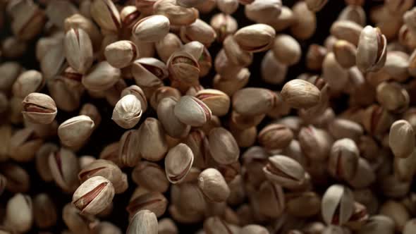 Super Slow Motion Shot of Pistachios Flies After Being Exploded Against Black Background 1000Fps