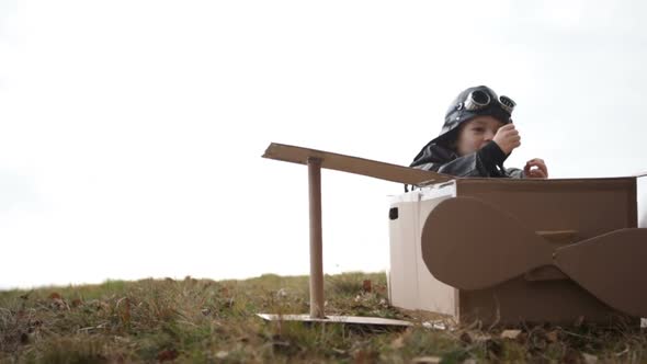 Young Pilot or Aviator Boy Plays and Smile with His Carboard Airplane Close Up