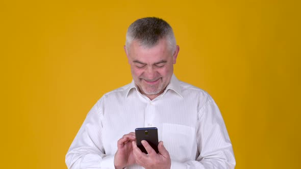 Handsome adult man uses smartphone texting messages in social media