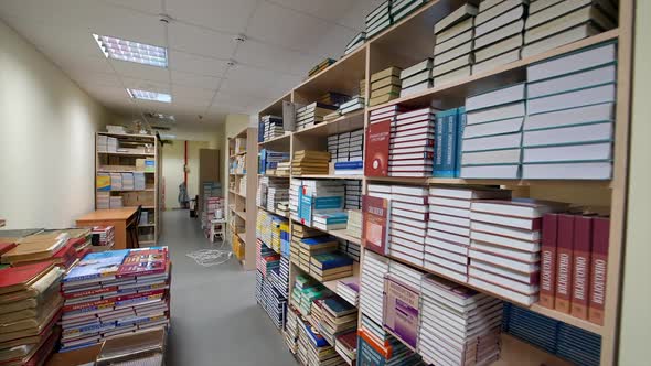 Books on wooden shelf in library. Modern design in library interior with functional shelf system