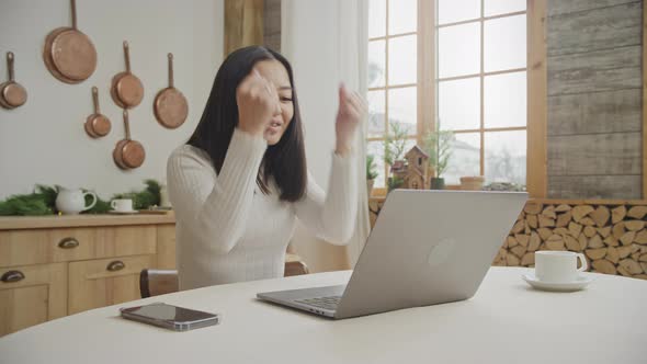 Young 20s Woman Recieving Good News on Her Laptop Indoors