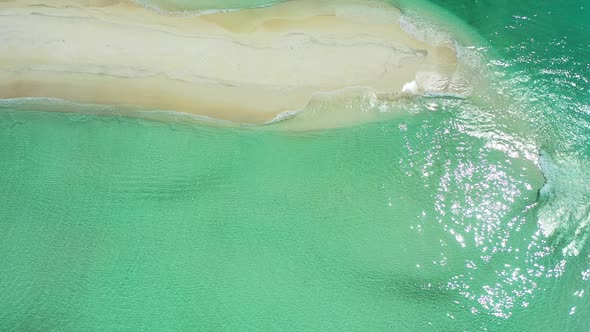 Beautiful fly over abstract shot of a white paradise beach and turquoise sea background in 4K