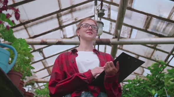 Blonde Girl Goes to Work on a Flower Greenhouse