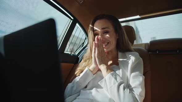 Smiling Businesswoman Rejoicing at Good News on Laptop in Luxury Automobile