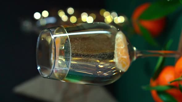 Sparkling Wine with Tangerine is Stired in Wineglass on Table with Mandarins Fir Brunch and Garland