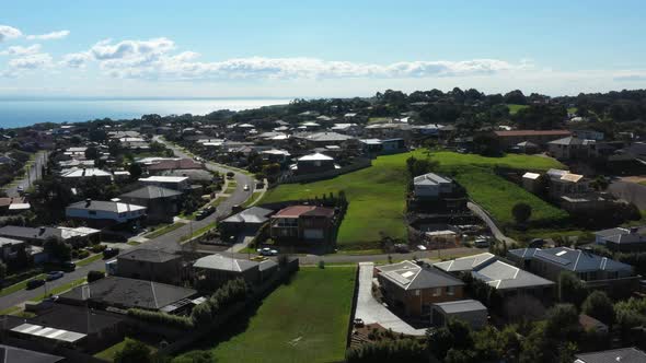 AERIAL Housing Estate In Coastal Town With Vacant Lots On Sunny Day