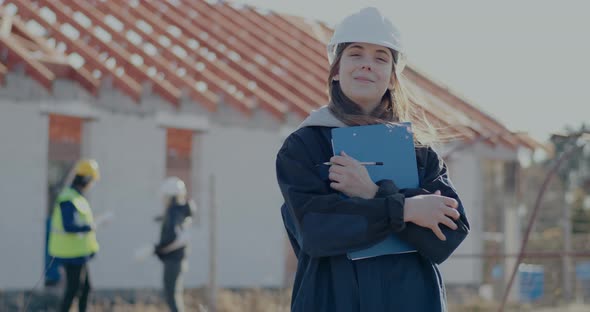 Smiling Young Female Building Contractor Holding Clipboard