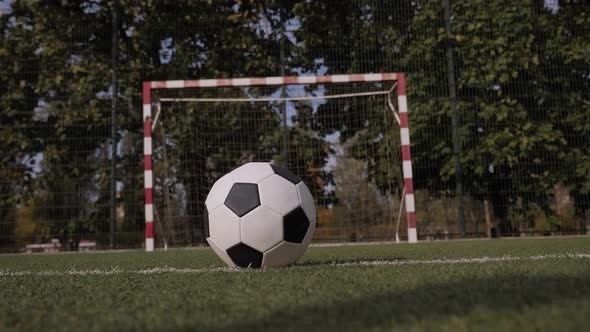 Closeup of a Schoolboy in Football Boots Hitting the Goal with a Soccer Ball