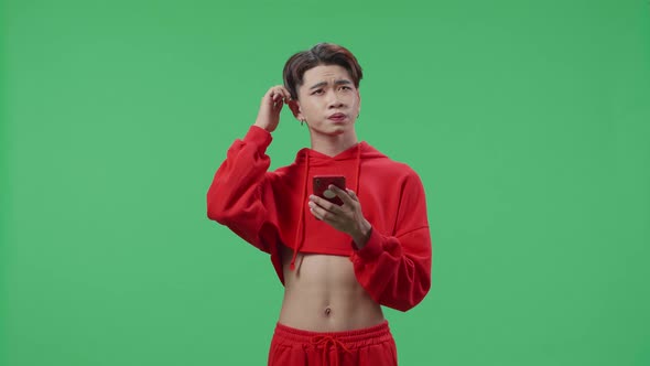 Young Asian Transgender Male Use Mobile Phone And Thinking About Something On Green Screen