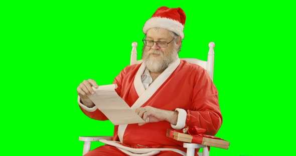 Santa claus holding scroll and gift box 4k
