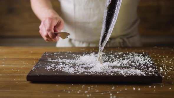 Chef Shakes Salt Out Off Herring Above Cutting Board