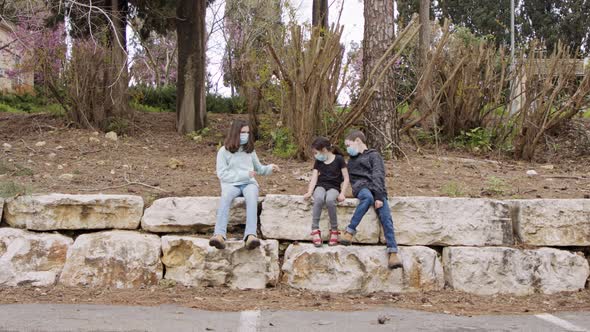 Coronavirus pandemic - kids wearing face masks to avoid contagion sitting bored