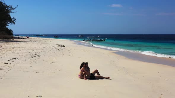 Boy and girl sunbathe on luxury coastline beach time by turquoise sea and white sandy background of 