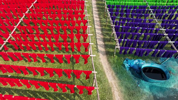 Aerial view of a person hanging to dry red cloths in Dhaka, Bangladesh.