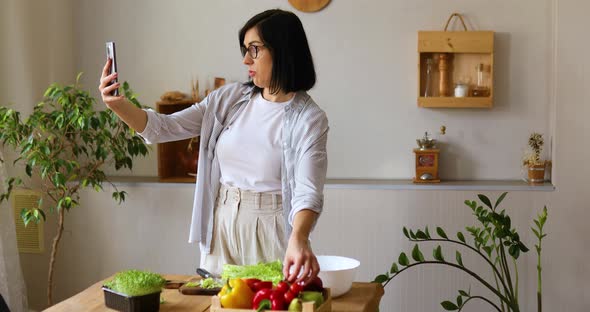 Woman makes a video lesson about cooking, on cellphone, smartphone