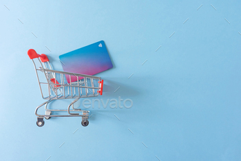 credit cart in shopping cart on blue background