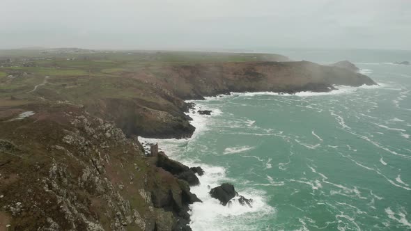 Aerial along the Atlantic shore and into the mist, Cornwall, England, part of the scenery used in th