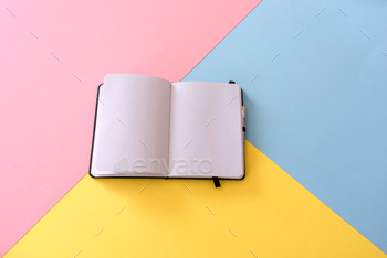 top view of Open notebook with blank pages on colorful background