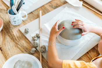 Ceramic workshop. Group of friends crafting a ceramic plate.