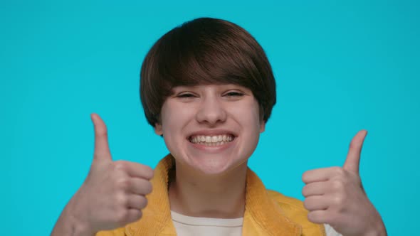 Cheerful Pretty Woman with Short Haircut Making Thumbs Up