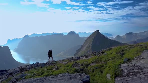 Aerial View of Girl with a Backpack Rises on a Mountain Ridge