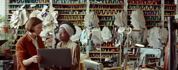 Women Working on Laptop and Talking in Shoemaking Workshop