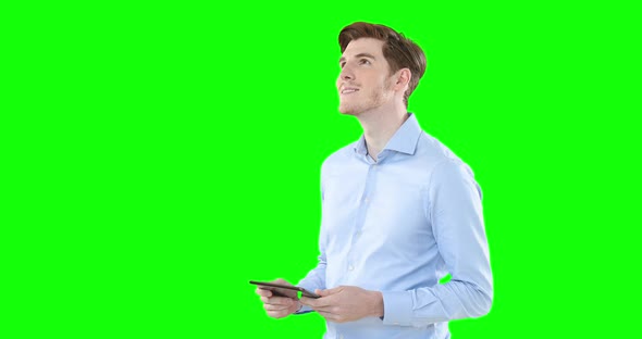 Man using digital tablet against green screen background