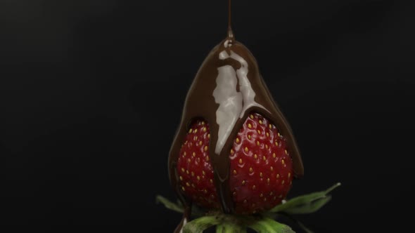 Ripe Juicy Strawberry Are Poured Over Chocolate on a Black Background. Close Up