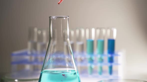 Glassware Containing Chemical Liquid for Research or Analyzing a Sample Into Test Tube in Laboratory