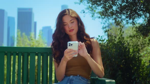 Calm Businesswoman Scrolling Phone in Park