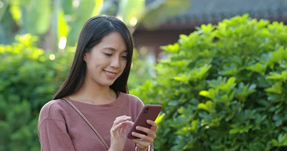 Woman Use of Mobile Phone Inside Chinese Garden