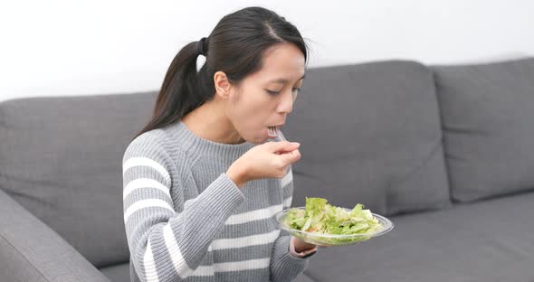 Woman eating salad at home