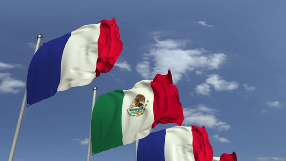 Waving Flags of Mexico and France on Sky Background
