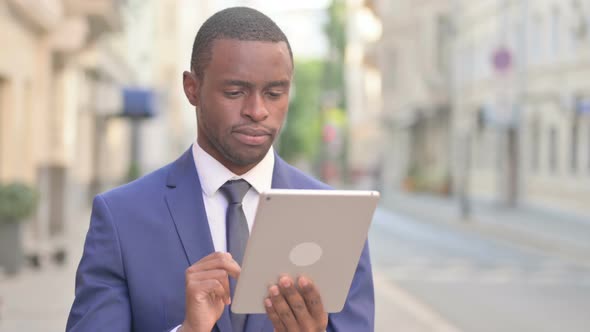 Outdoor Attractive African Businessman Using Tablet in Street